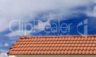 Roof tiles and blue sky with clouds