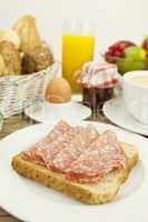 frisches frühstück mit toast, salami, ei und saft auf einem Ti