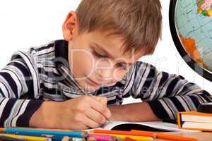 Cute schoolboy is writting