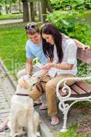 Young couple training dog in the park