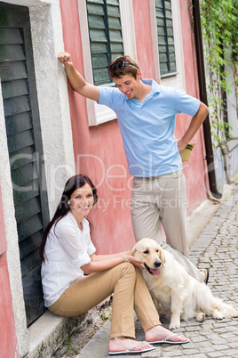 Happy couple resting with dog on street