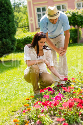 Young couple look flowers in sunny park