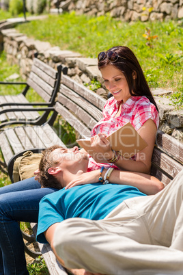 Young happy couple relax on bench park
