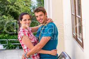 Happy young couple hugging outdoors smiling