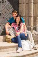 Young couple sitting on building steps smiling