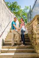 Young couple smiling holding hands on stairs