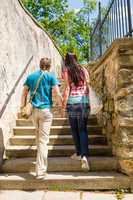 Couple climbing up city stairs holding hands
