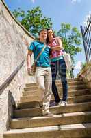 Young happy couple walking down stairs smiling