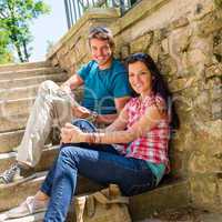 Happy young couple sitting on stairs smiling