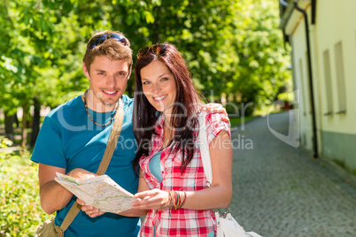 Happy couple looking on map in park