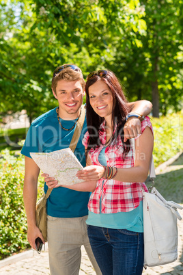 Happy couple looking on map in park