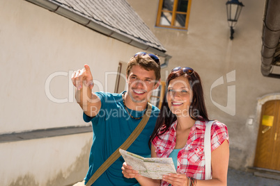 Young couple in city man pointing direction