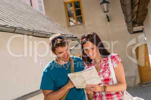 Happy couple looking at map in town