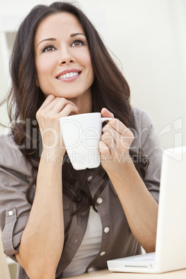 Beautiful Woman Using a Computer and Drinking Tea or Coffee