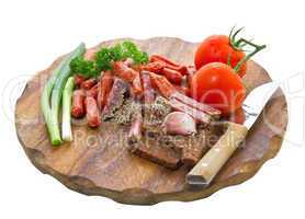 assortment of salami and vegetables on a cutting board
