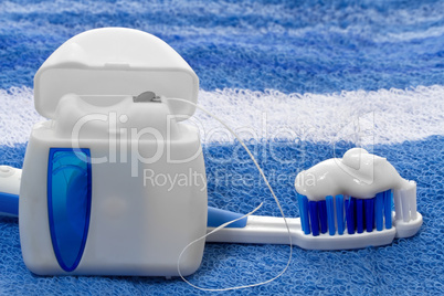 dental floss and toothbrush on a towel