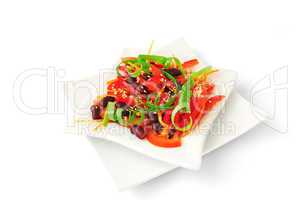 A salad of tomatoes, sweet peppers, red beans, carrots with sesa