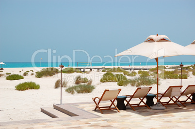 Sunbeds and umbrellas at the beach of luxury hotel, Abu Dhabi, U