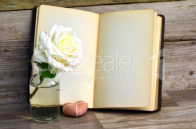 Buch und Rose auf altem Holz Hintergrund