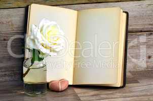 Buch und Rose auf altem Holz Hintergrund