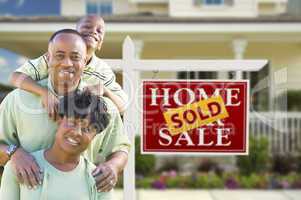 African American Family In Front of Real Estate Sign and House