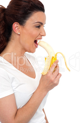 Side view of brunette women eating banana