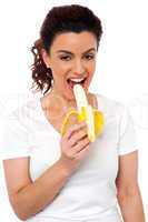 Beautiful young fit girl eating banana