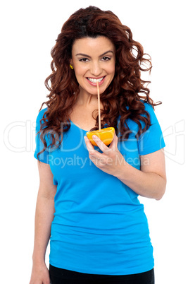 Fit girl drinking fresh orange juice directly from fruit