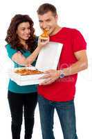 Caring girlfriend making her boyfriend eat pizza
