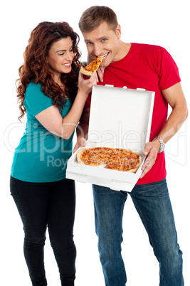 Girl sharing a pizza piece with her boyfriend