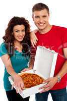 Cheerful love couple enjoying pizza together