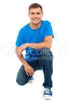 Casual cool young guy semi seated on floor
