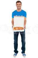 Casual guy showing freshly baked yummy pizza
