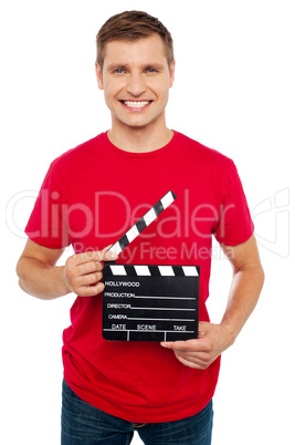 Smiling young guy holding clapperboard