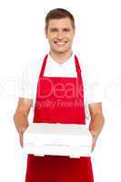 A chef in red uniform offering you a pizza box