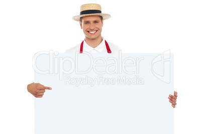 Portrait of cheerful chef pointing at placard