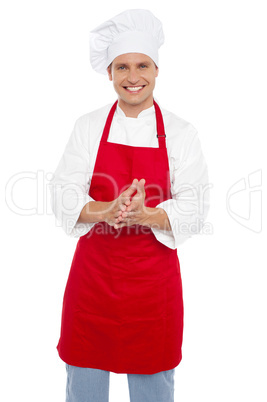 Cheerful confident male chef in proper uniform