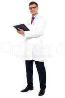 Full length shot of physician posing with clipboard