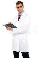 Handsome doctor writing prescription
