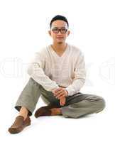Asian man sitting on floor