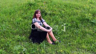 Woman Sits On Grass