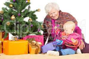 Gran and baby unwrapping Christmas gifts