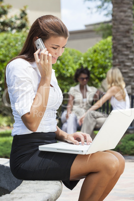 Young Woman On Cell Phone Using Laptop Computer