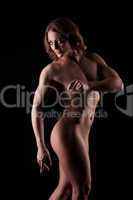 Perfect woman muscular body builder posing in dark
