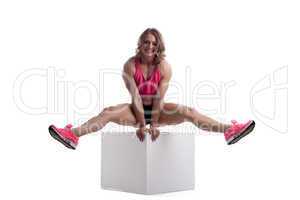 Happy woman with perfect body sit on cube
