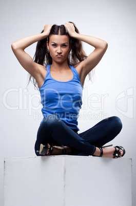 Sexy brunette sit in jeans and blue tank top