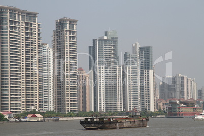 Cargo ship on the river Huangpu and new buildings