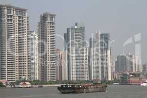 Cargo ship on the river Huangpu and new buildings