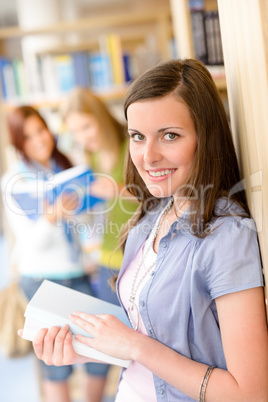 Teenage student with book at school library