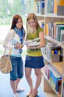 Girl friends studying books together in library